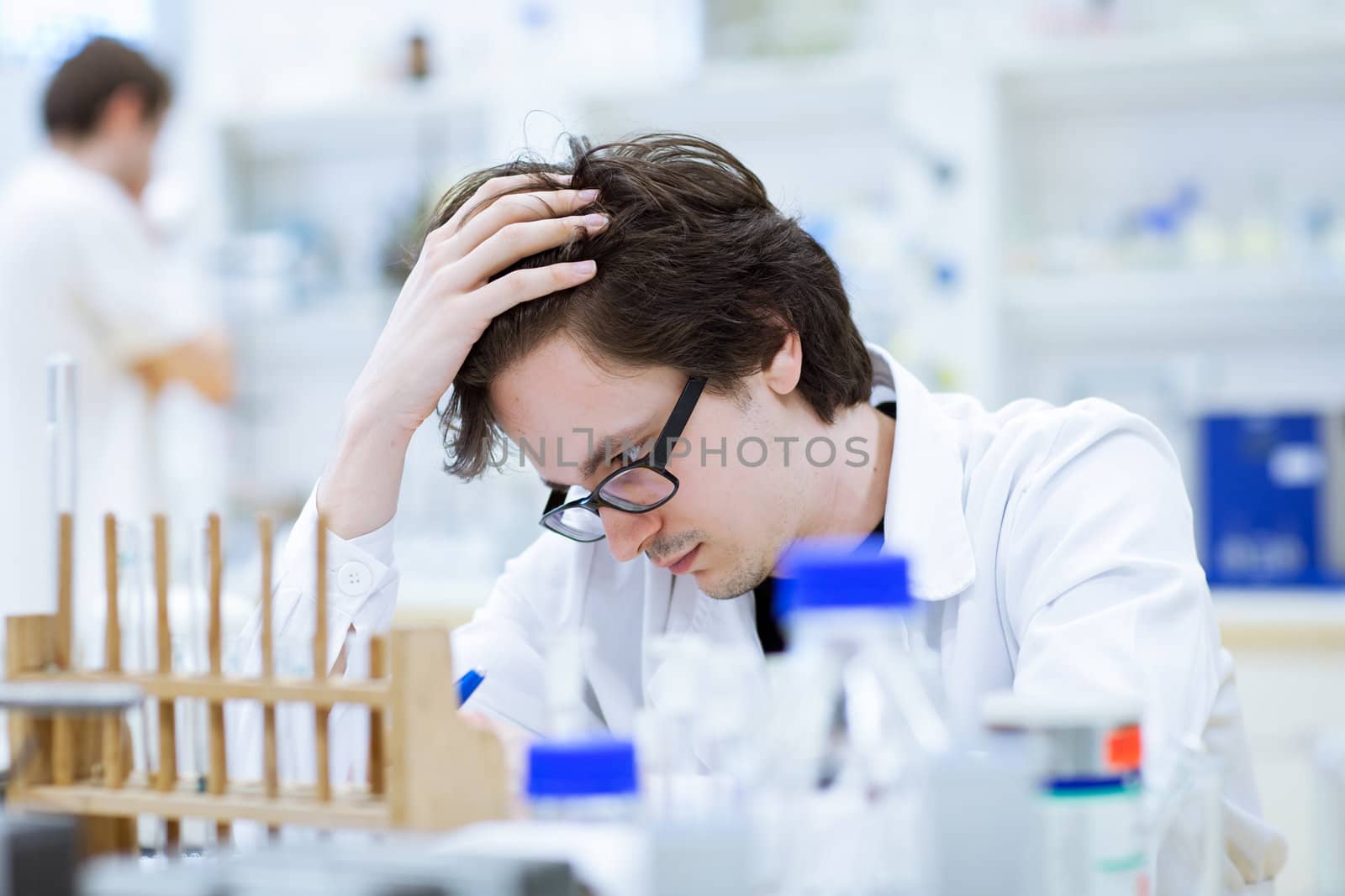 young, male researcher/chemistry student carrying out scientific research in a lab (shallow DOF; color toned image)