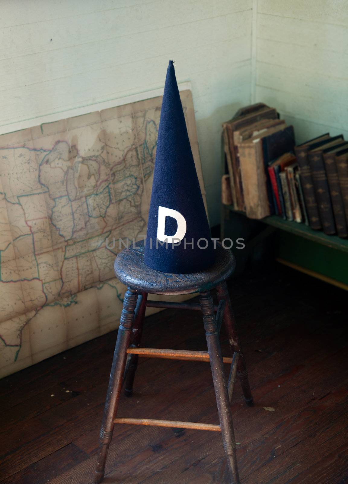 Dunce cap standing on a stool in an old schoolhouse