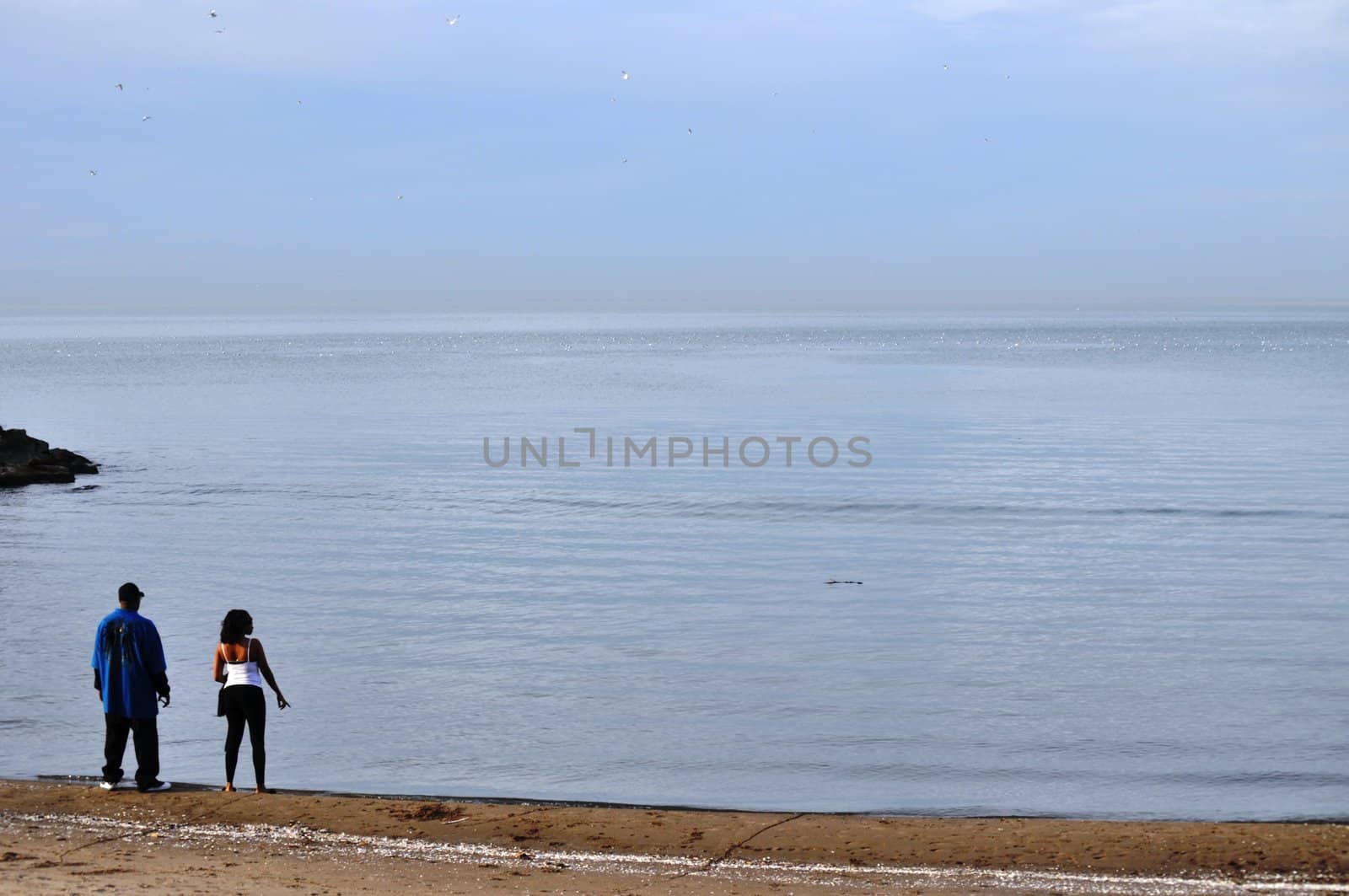 Couple stares out at Lake Erie by RefocusPhoto