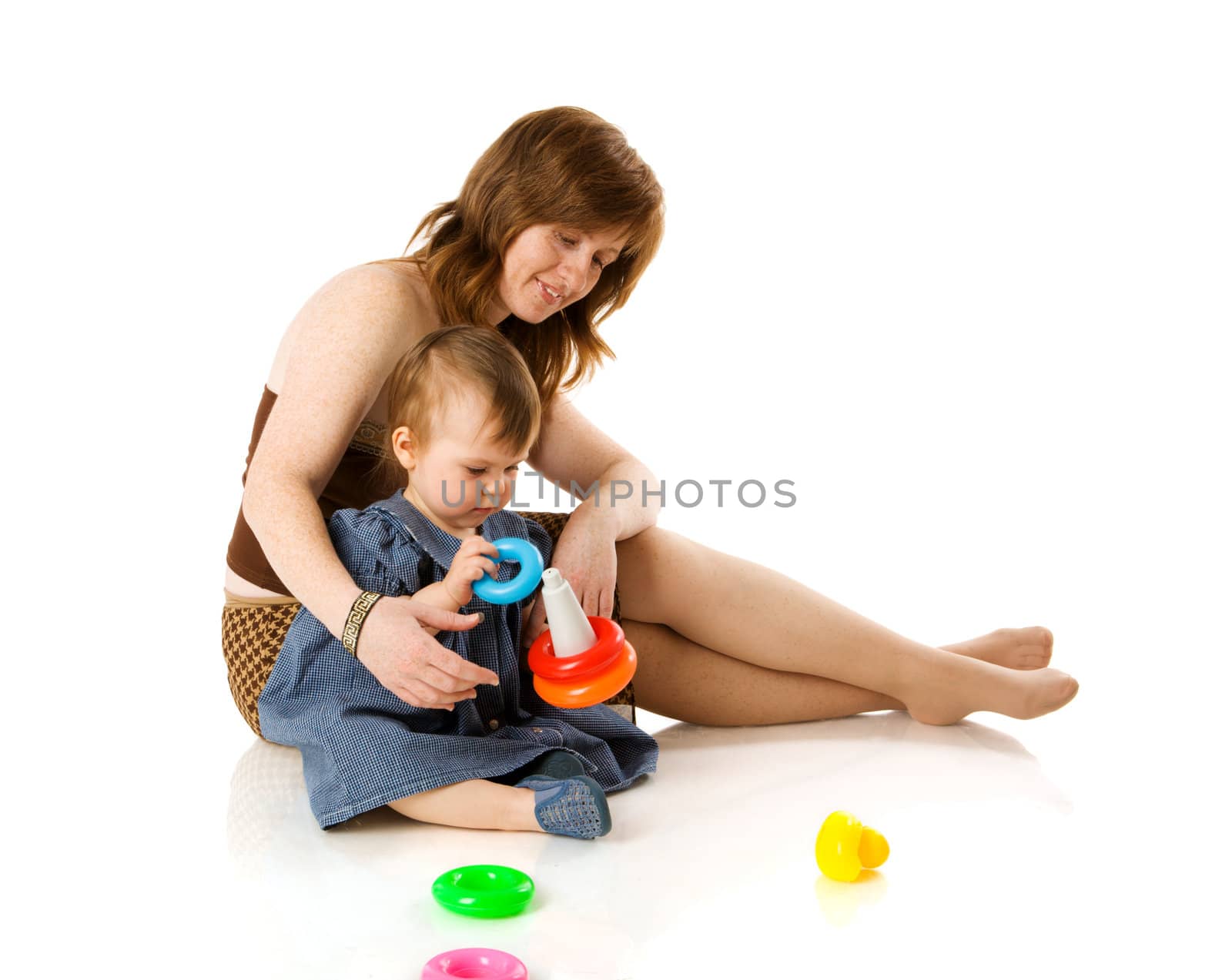 Mother playing with baby girl sitting isolated on white