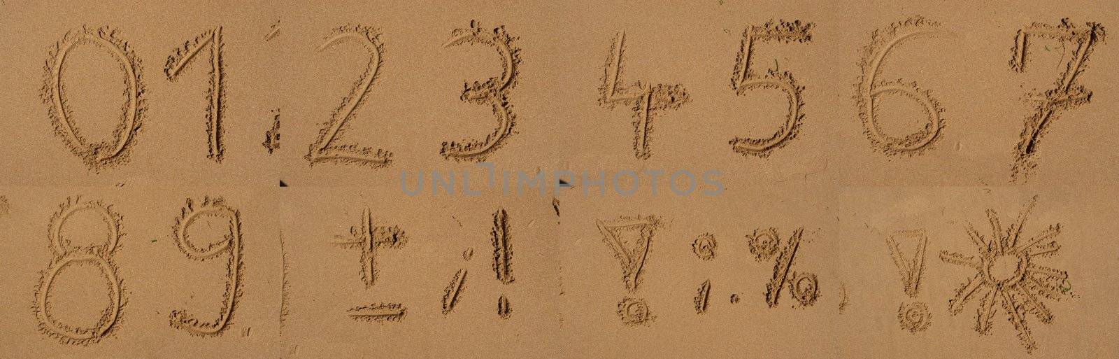 The alphabet written in sand on a beach.