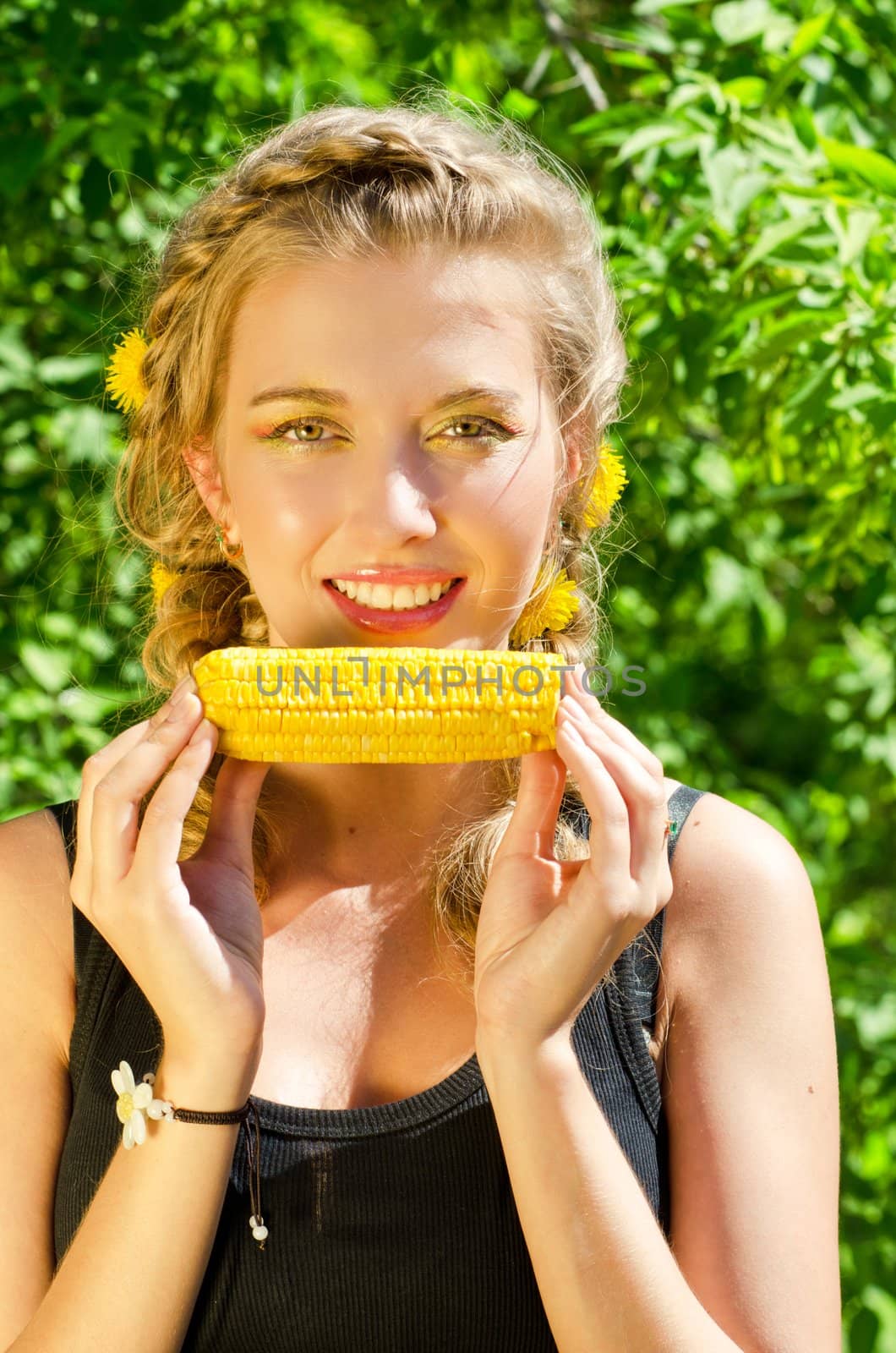 Close-up outdoor portrait of young beauty woman eating corn-cob