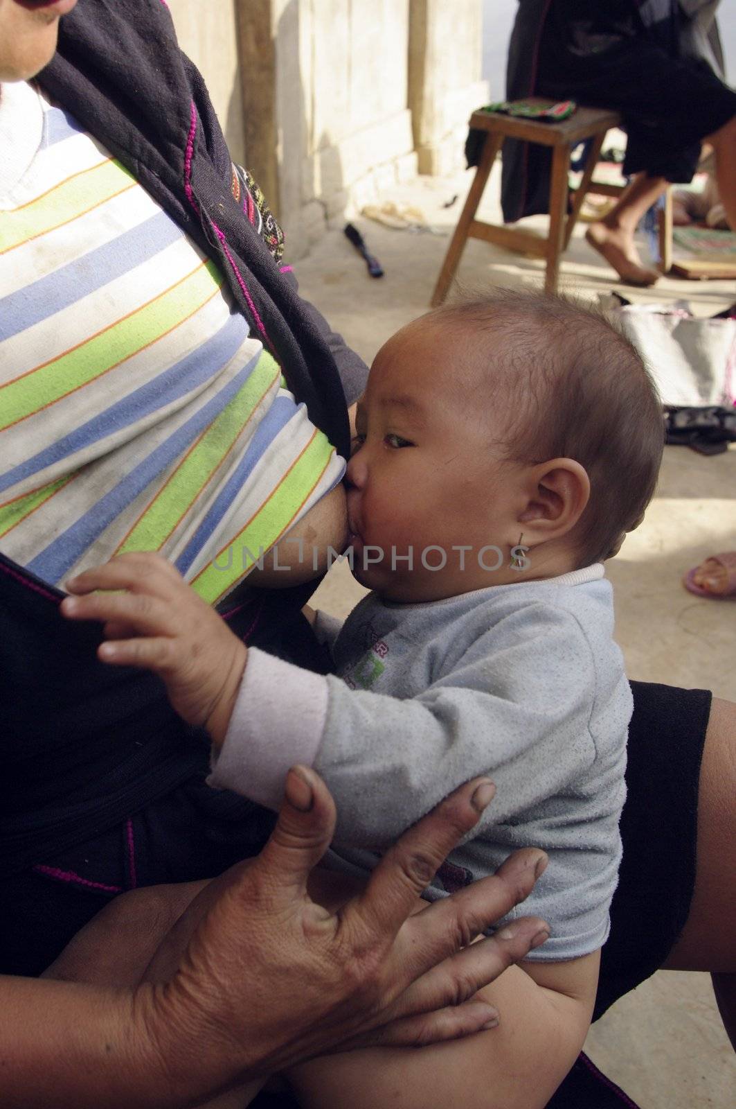 Black Hmong woman breast feeding her daughter