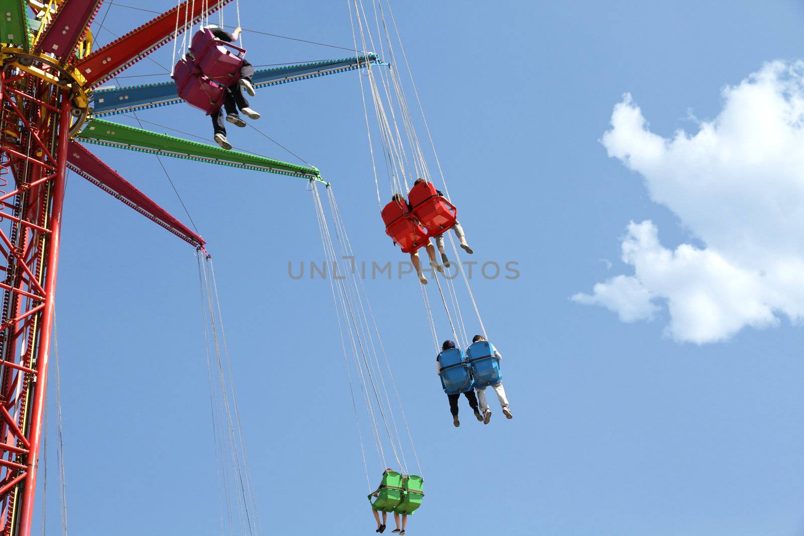 Colored carousel in an amusement park against blue sky