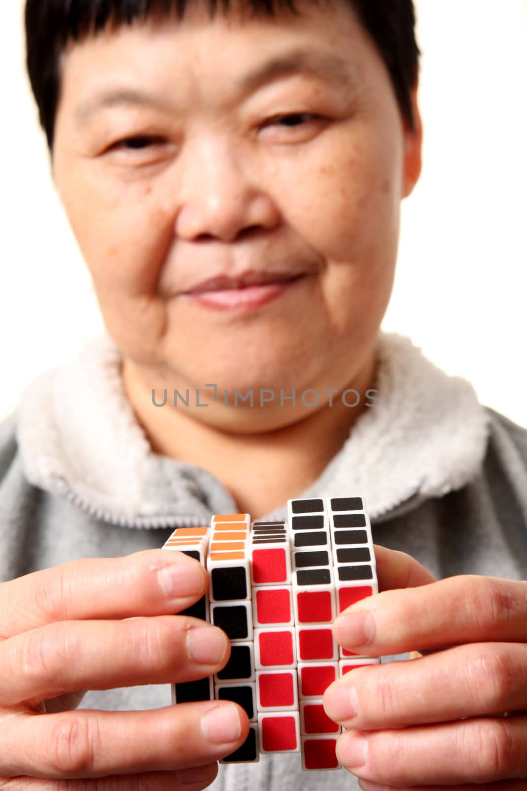 senior chinese woman playing  rubik cube by cozyta