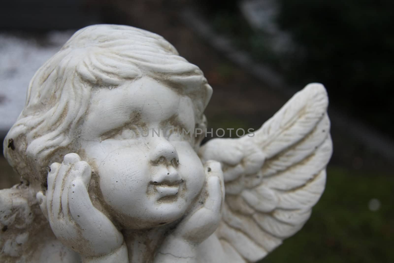 Detail of a white concrete Guardian Angel grave ornament
