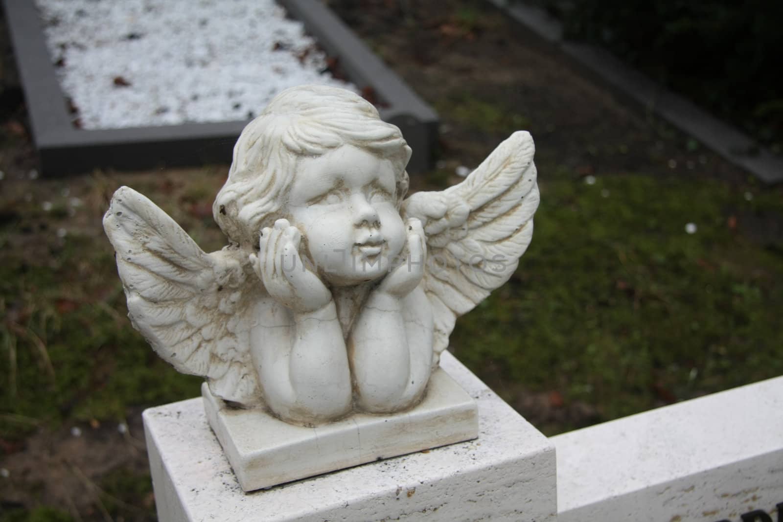white concrete Guardian Angel grave ornament on a graveyard