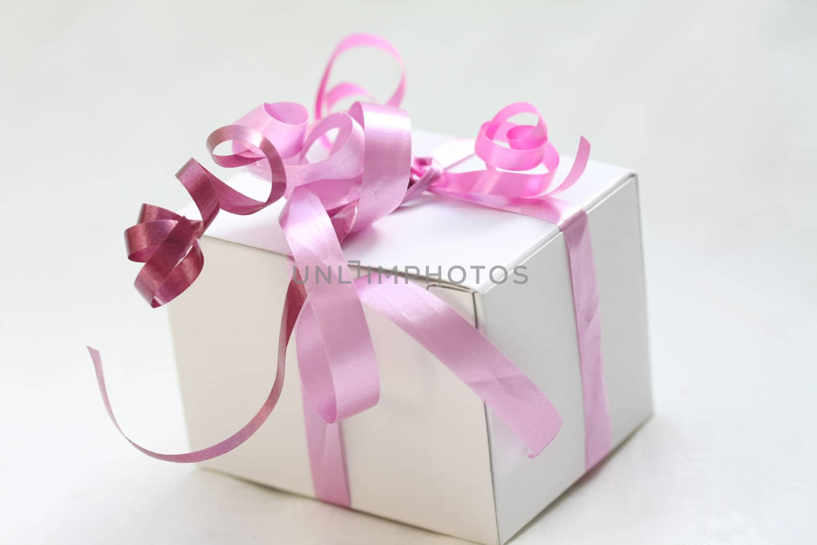 A white gift box with pink ribbons