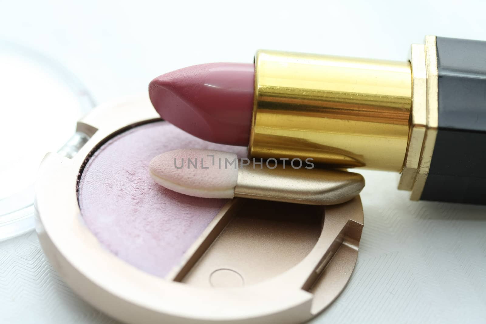 A solitaire pink eye shadow palet and a pink lipstick