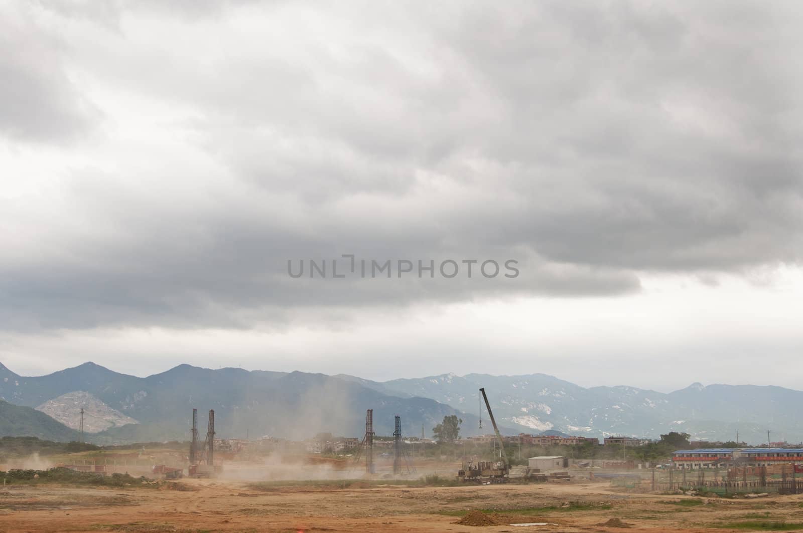 Dust flies with construction in developing Asia with mountains in the background