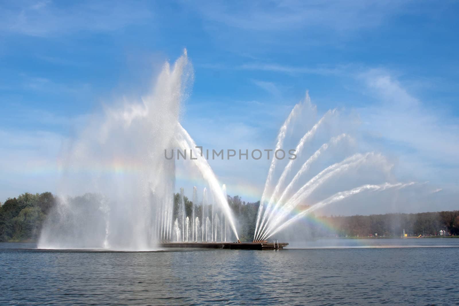 bright blue sky and fountain with rainbow