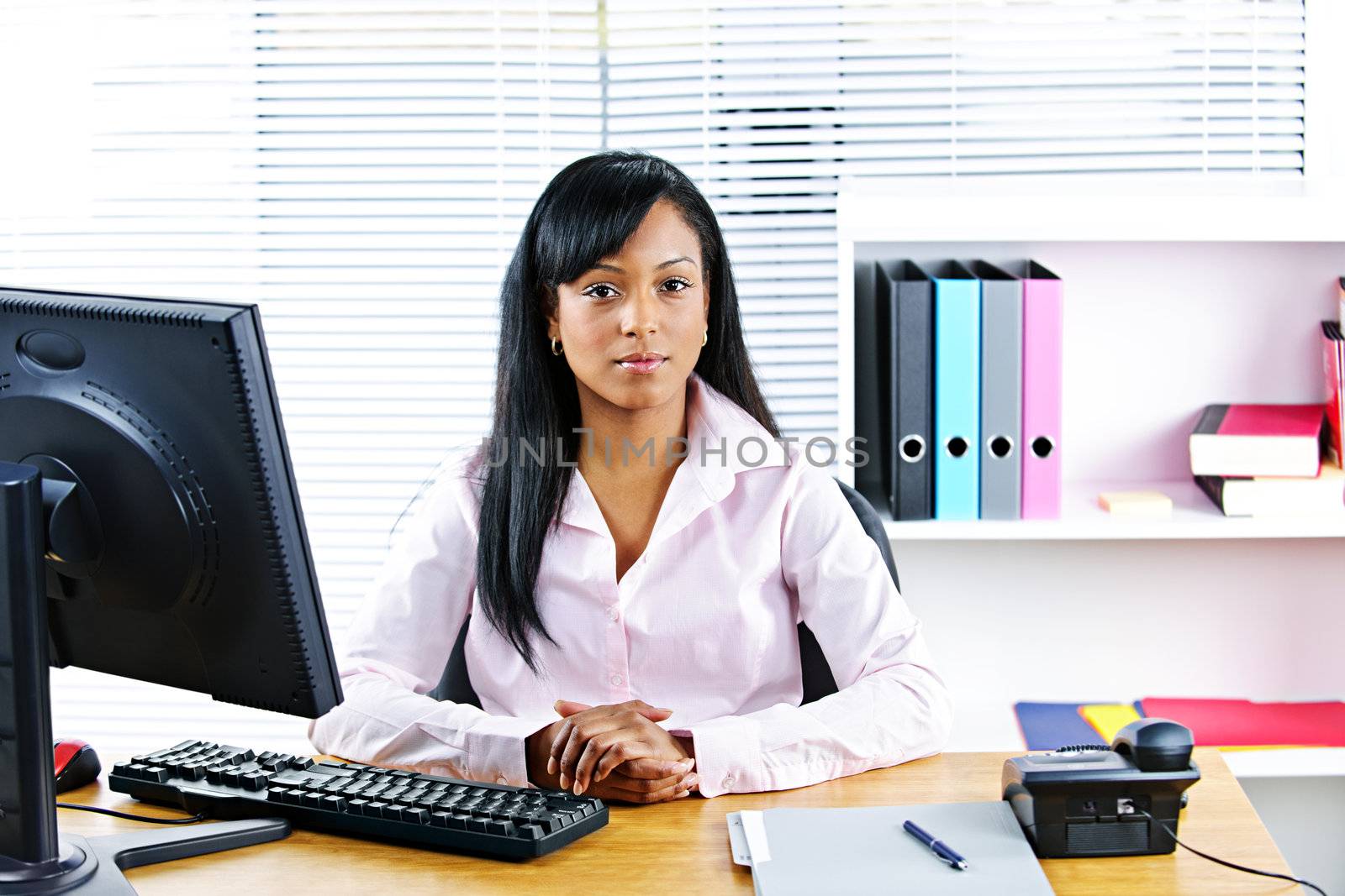 Black businesswoman at desk by elenathewise