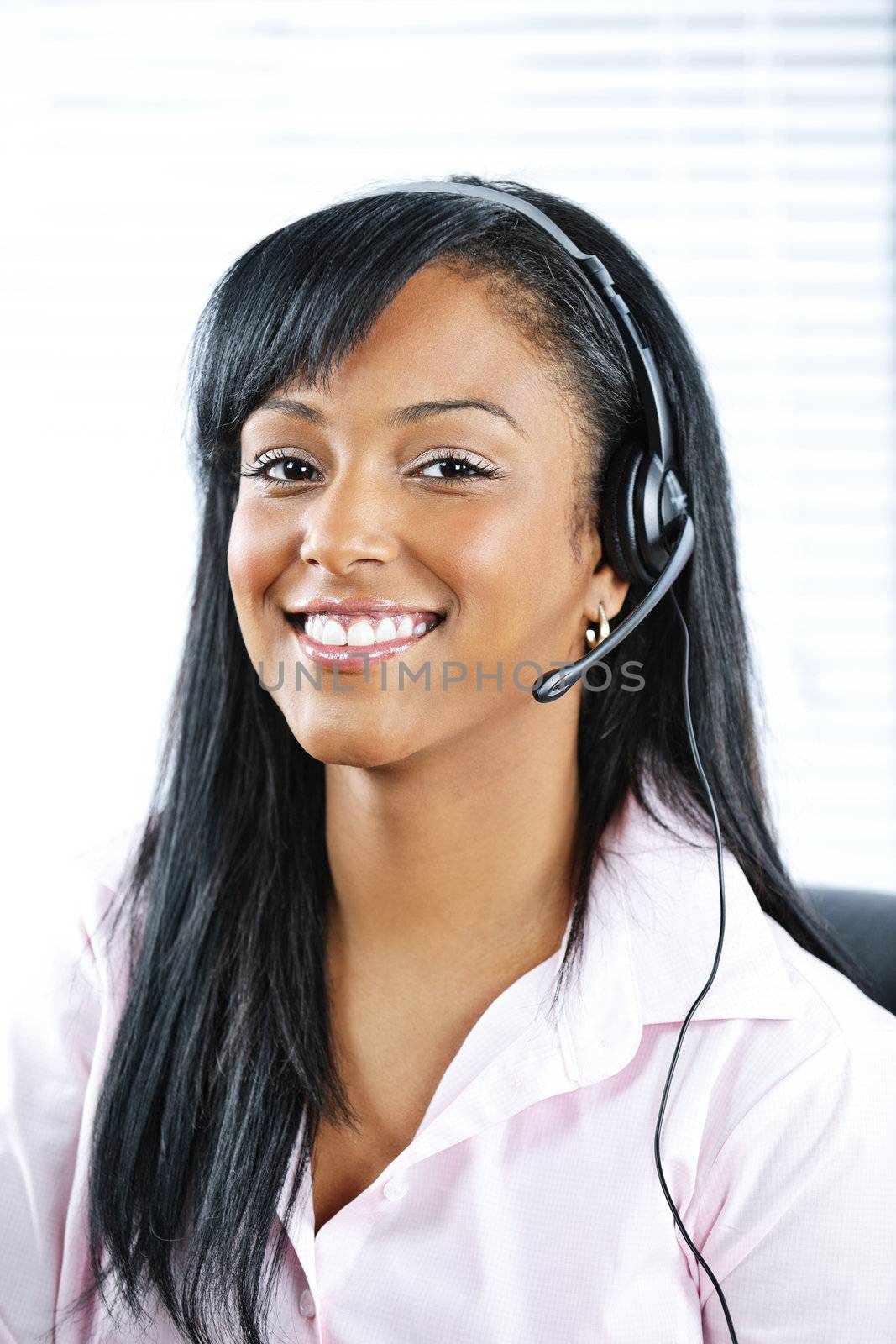 Smiling black customer service and support woman wearing headset