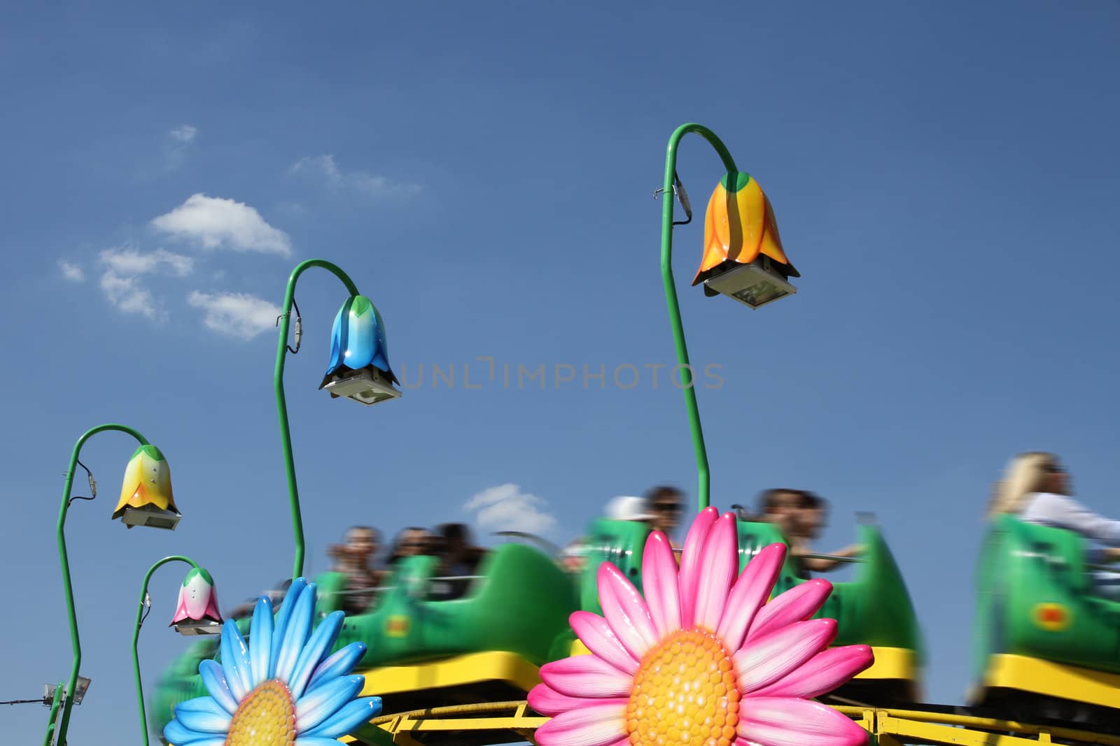 rollercoaster for childrens in an amusement park against blue sky