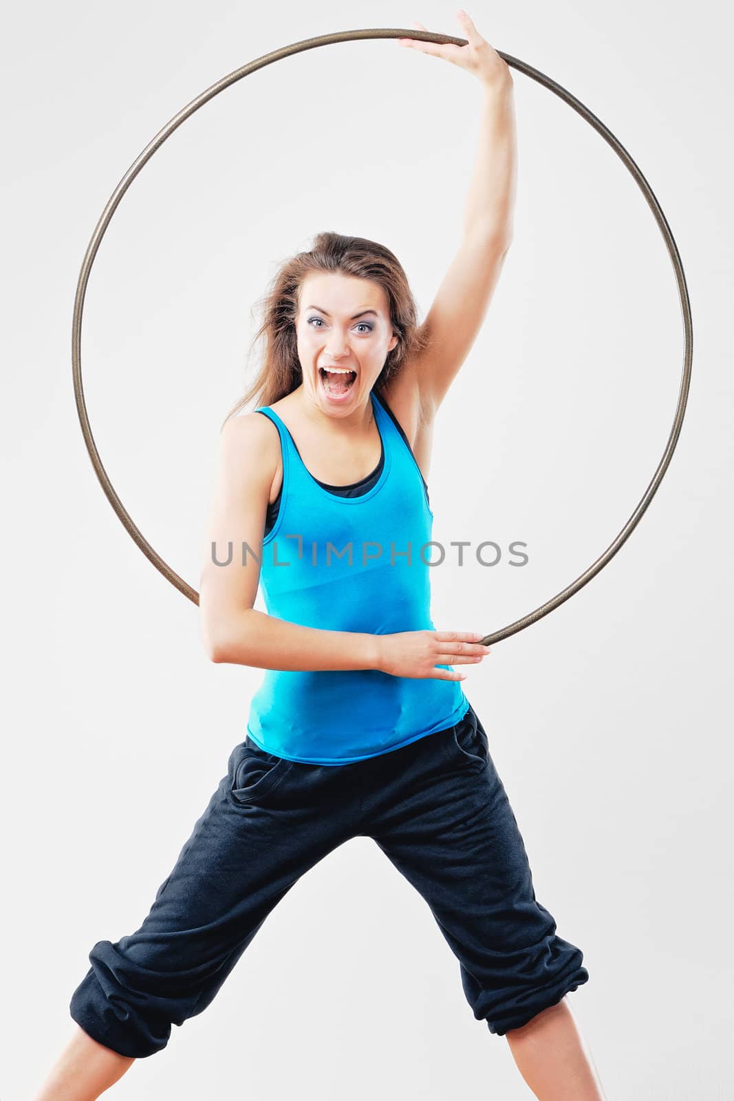 Young women in tracksuit with hula-hoop in studio