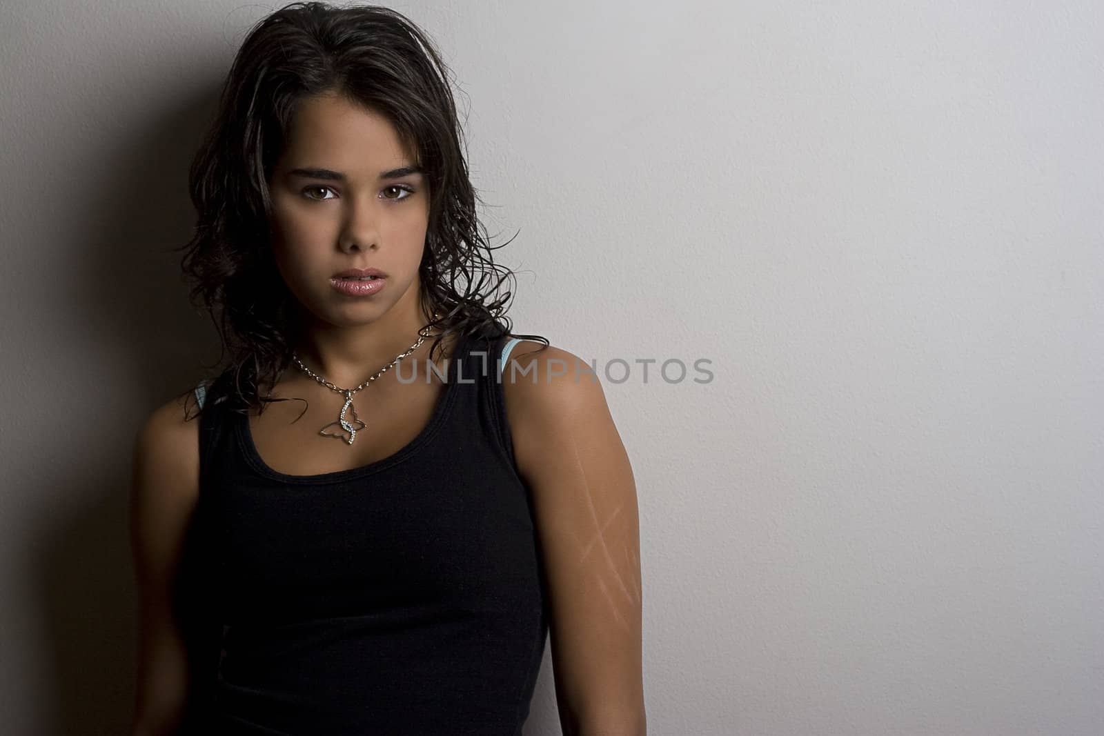 Young woman against a white wall with scares on her arm