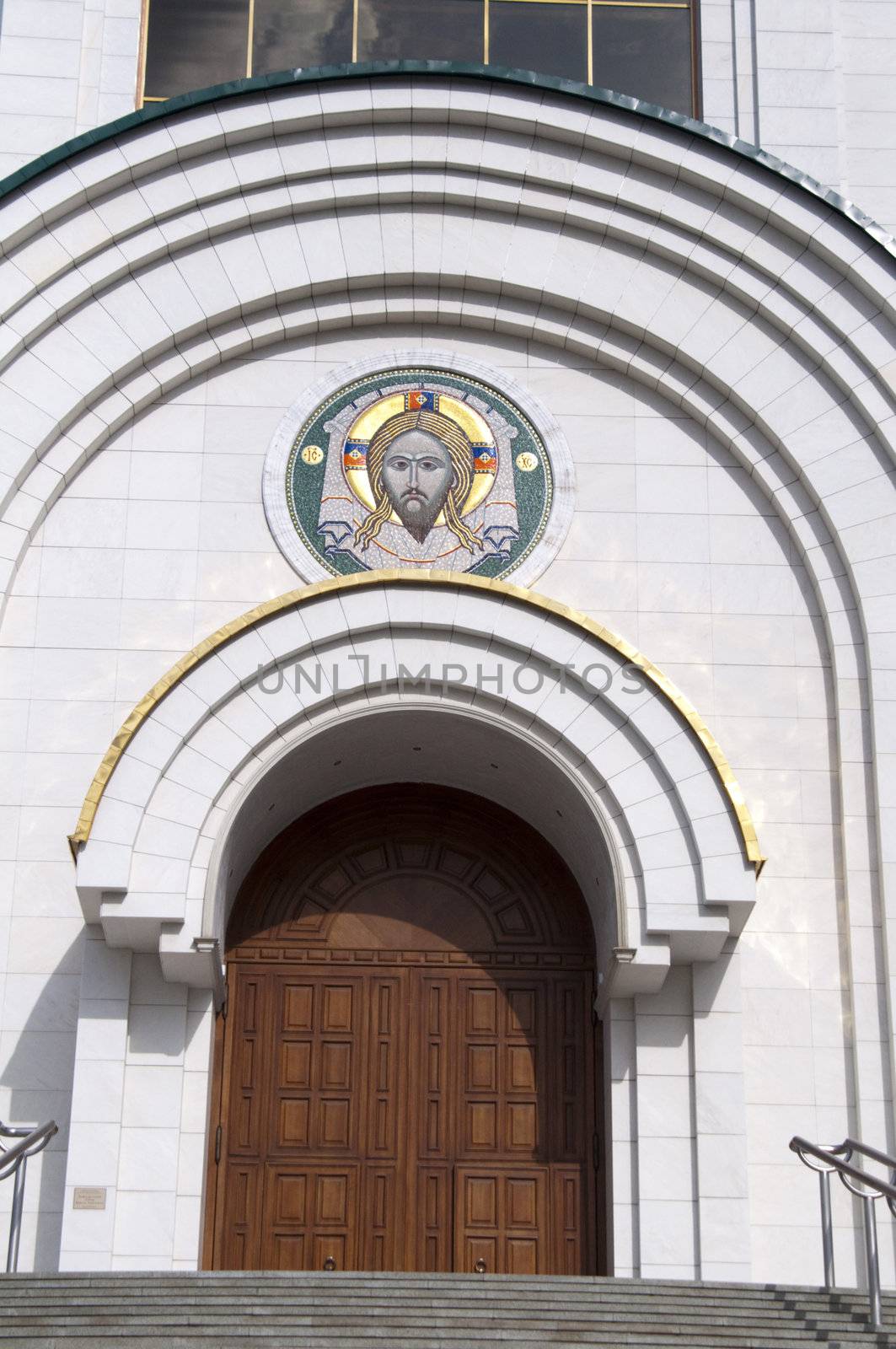 High resolution image. Russian cathedral with gold cupola, bell-tower and icons over entrances.