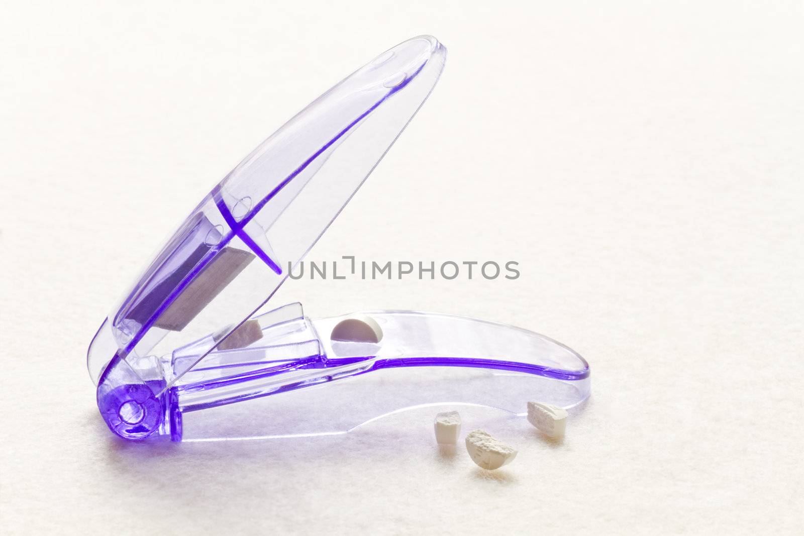 Purple pill cutter with pills in close view