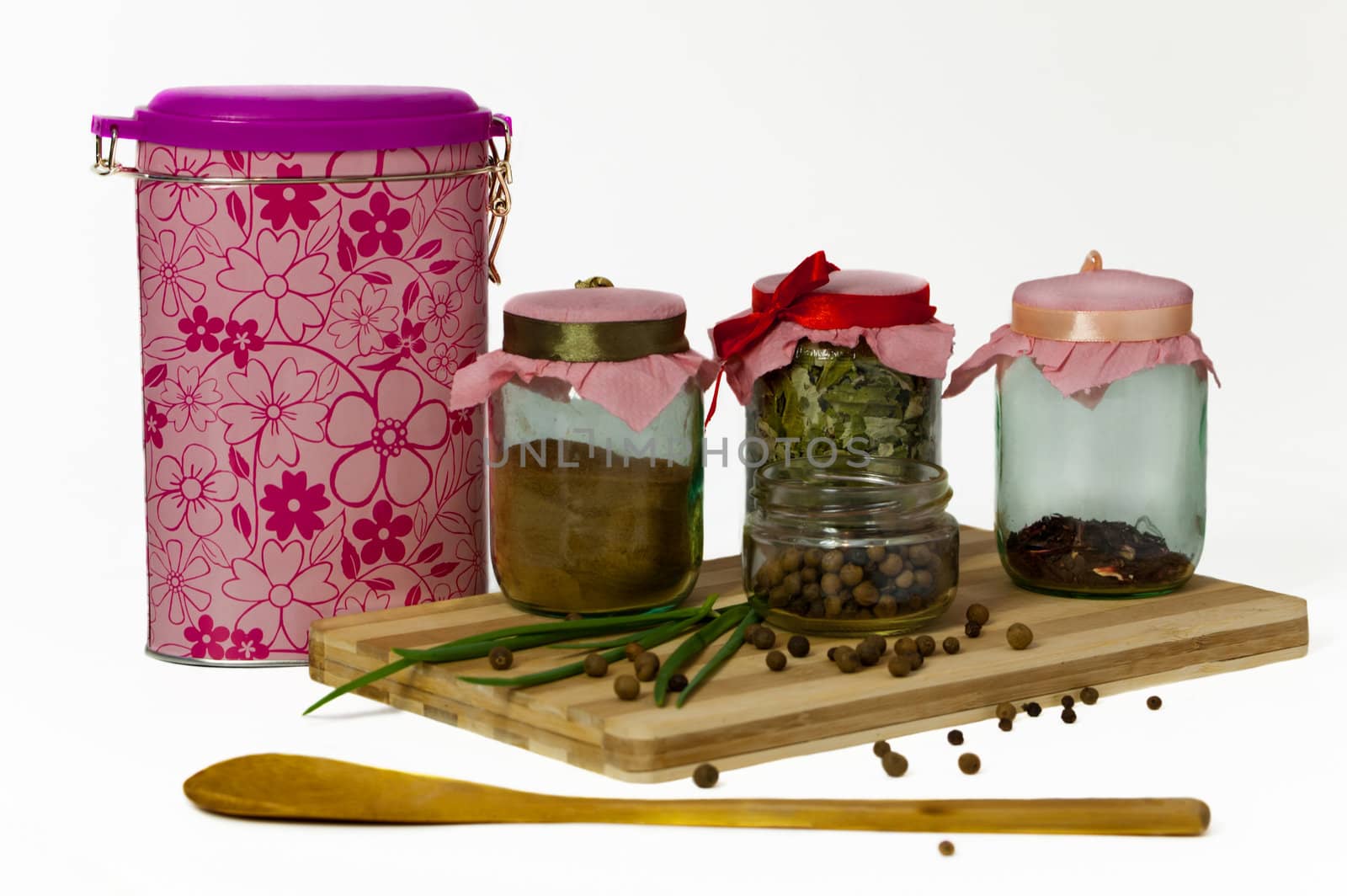 Different spices in jars on a white background