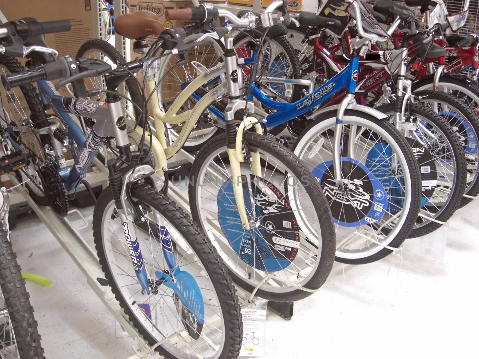 A range of brand new bicycles are neatly displayed inside a bicycle shop.