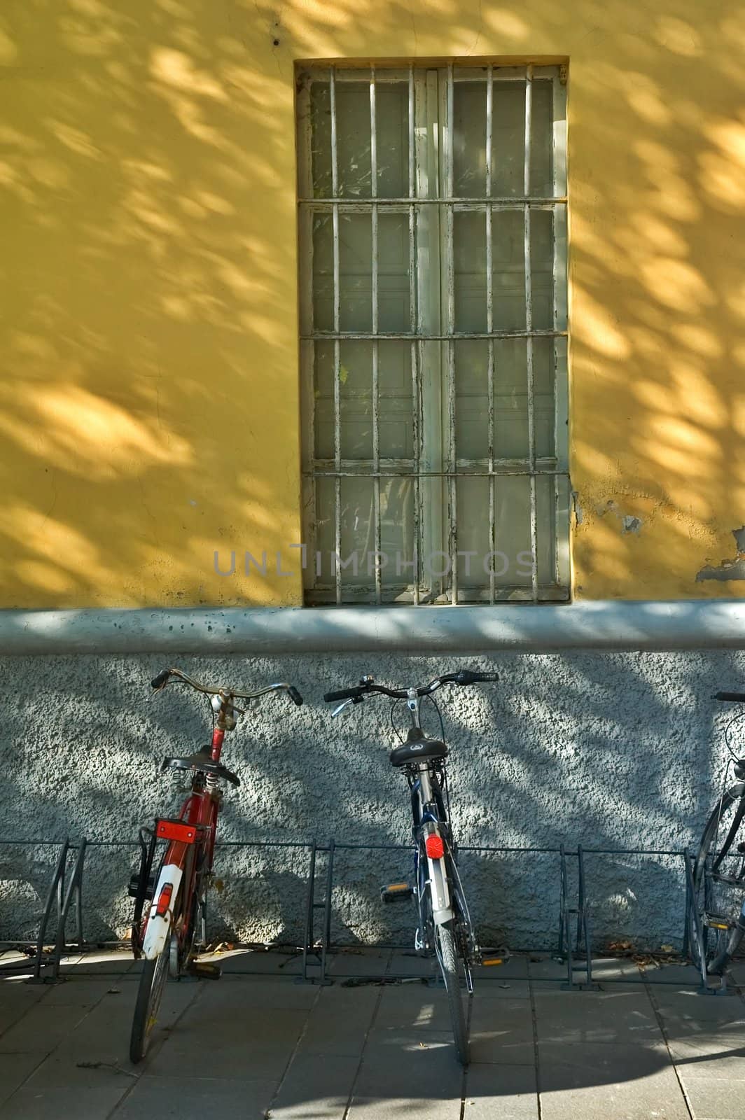 Bicycles under window on Italian sidewalk