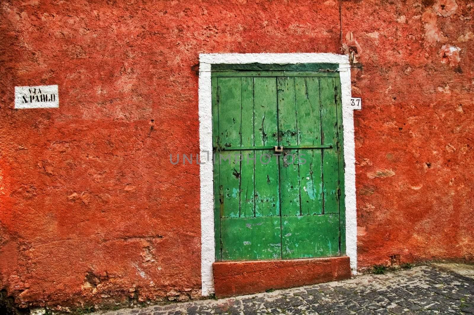 Old Italian red wall with green wooden door