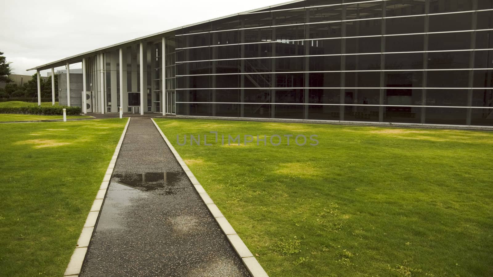 modern architecture composition, glass wall and straight road to hall's entrance