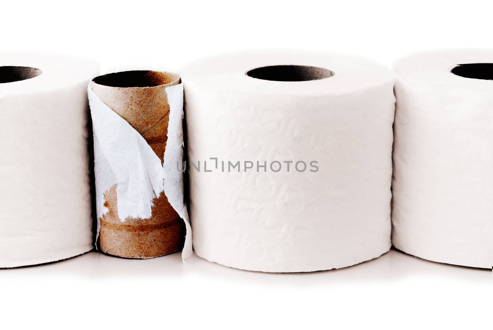 Toilet paper rolls in a row with a used up one among them