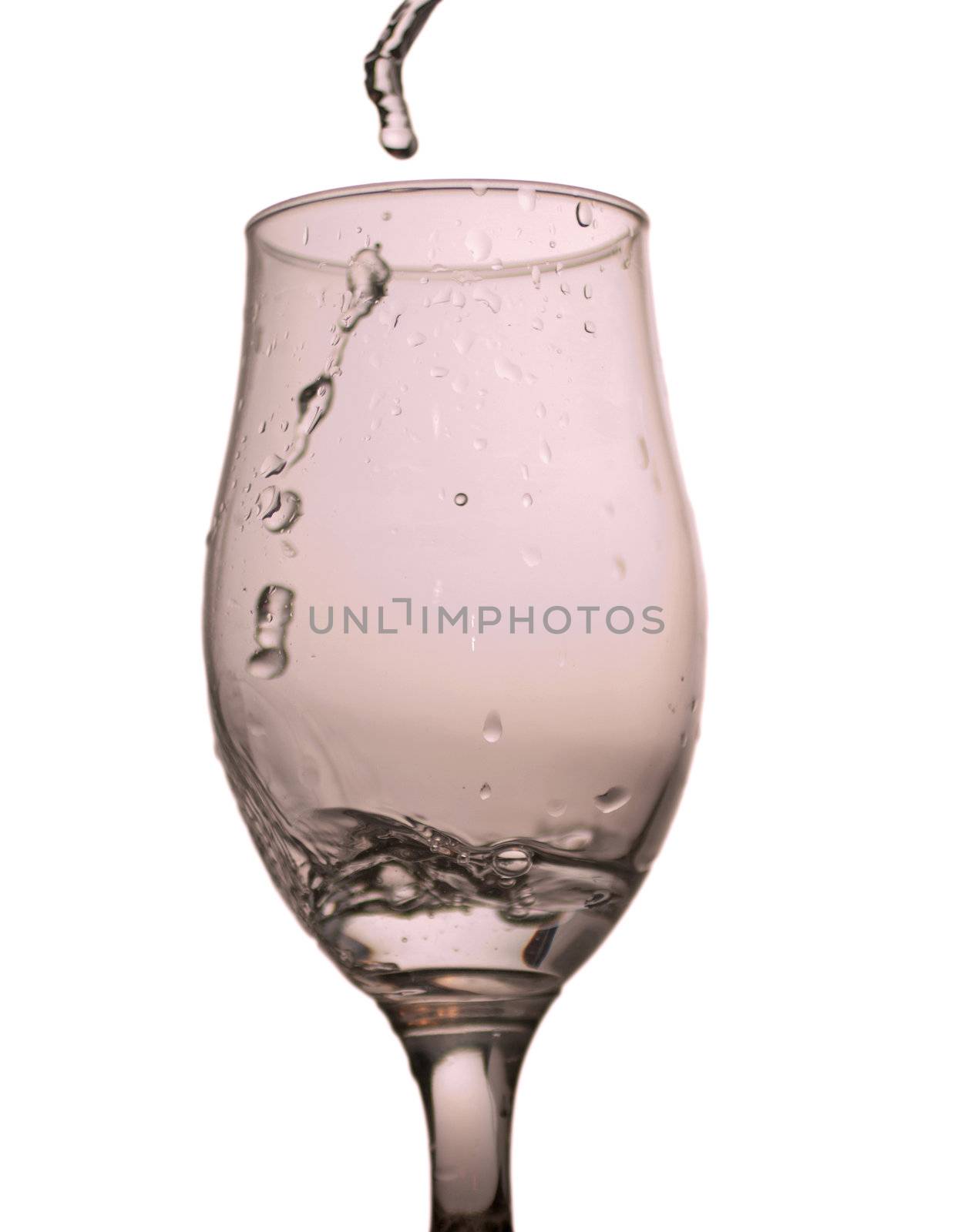 A glass with water pouring from above