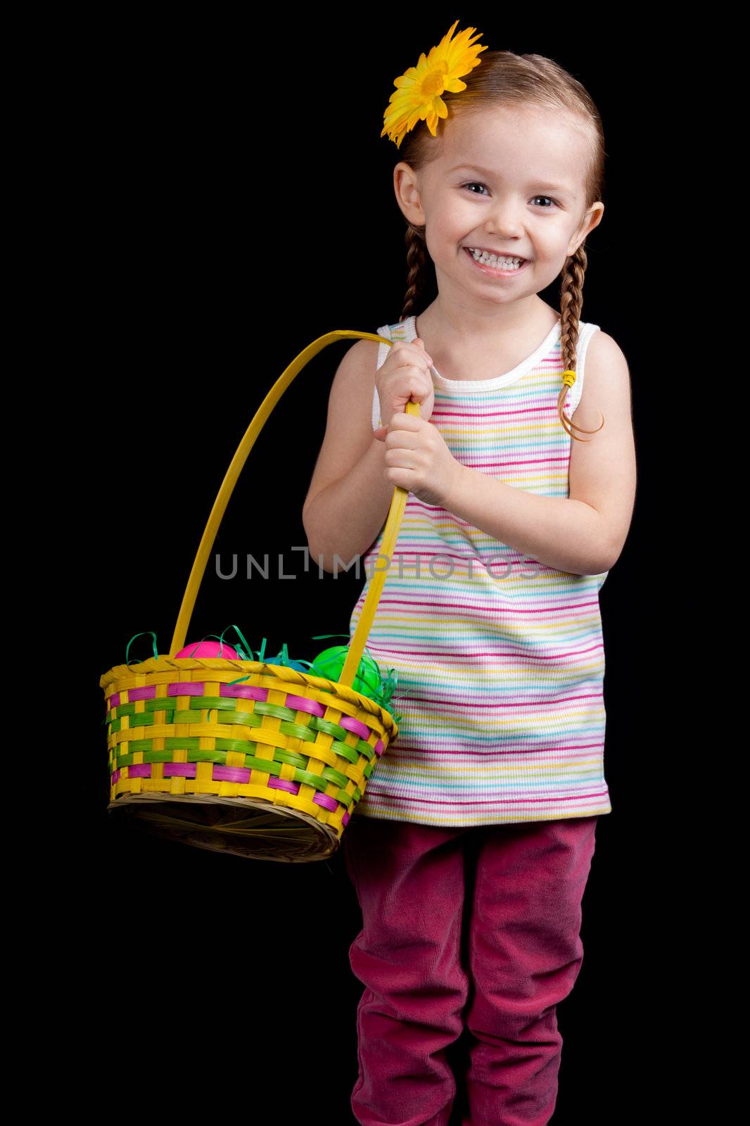 A happy young girl holding her easter basket.  She is on the hunt for more eggs.