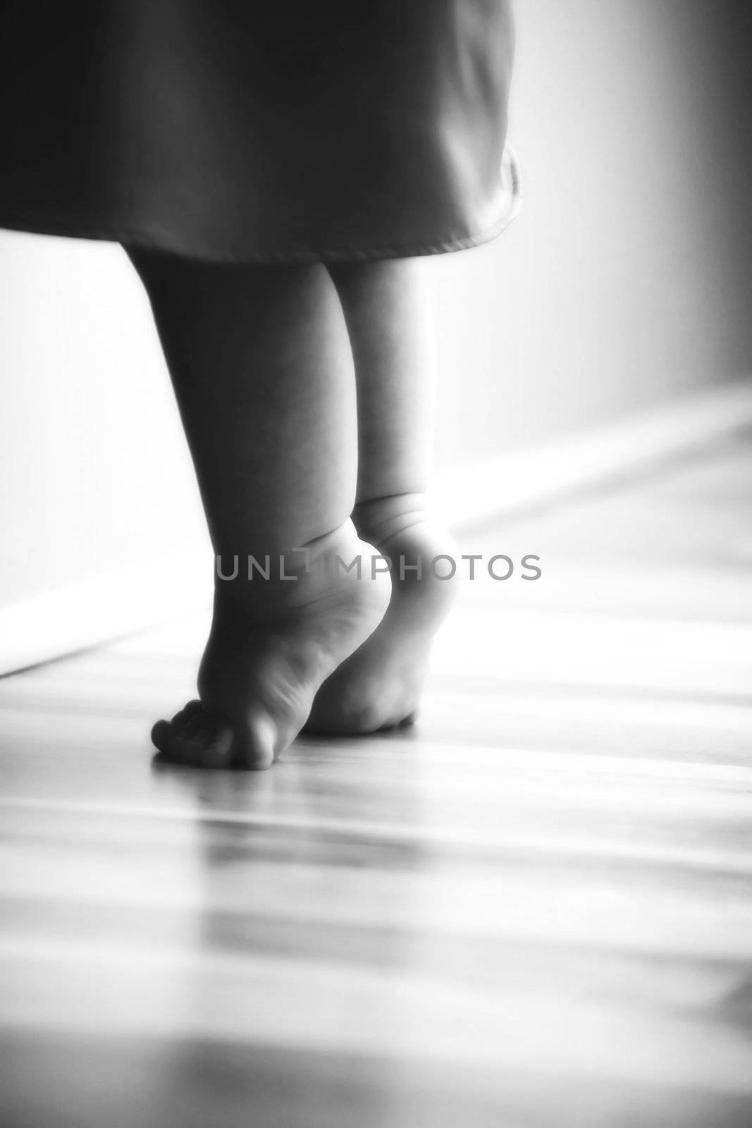 Baby Feet Stretching on Wooden Floor black and white