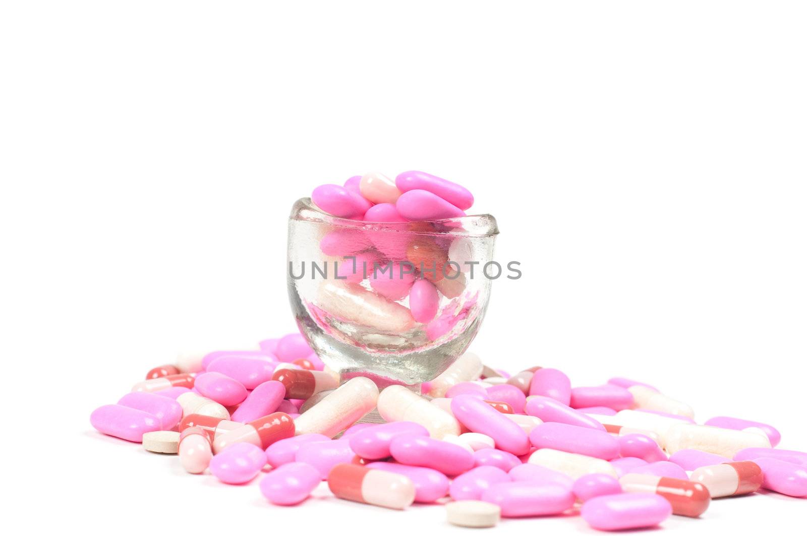 Shot of pink drugs (tablets) isolated on white