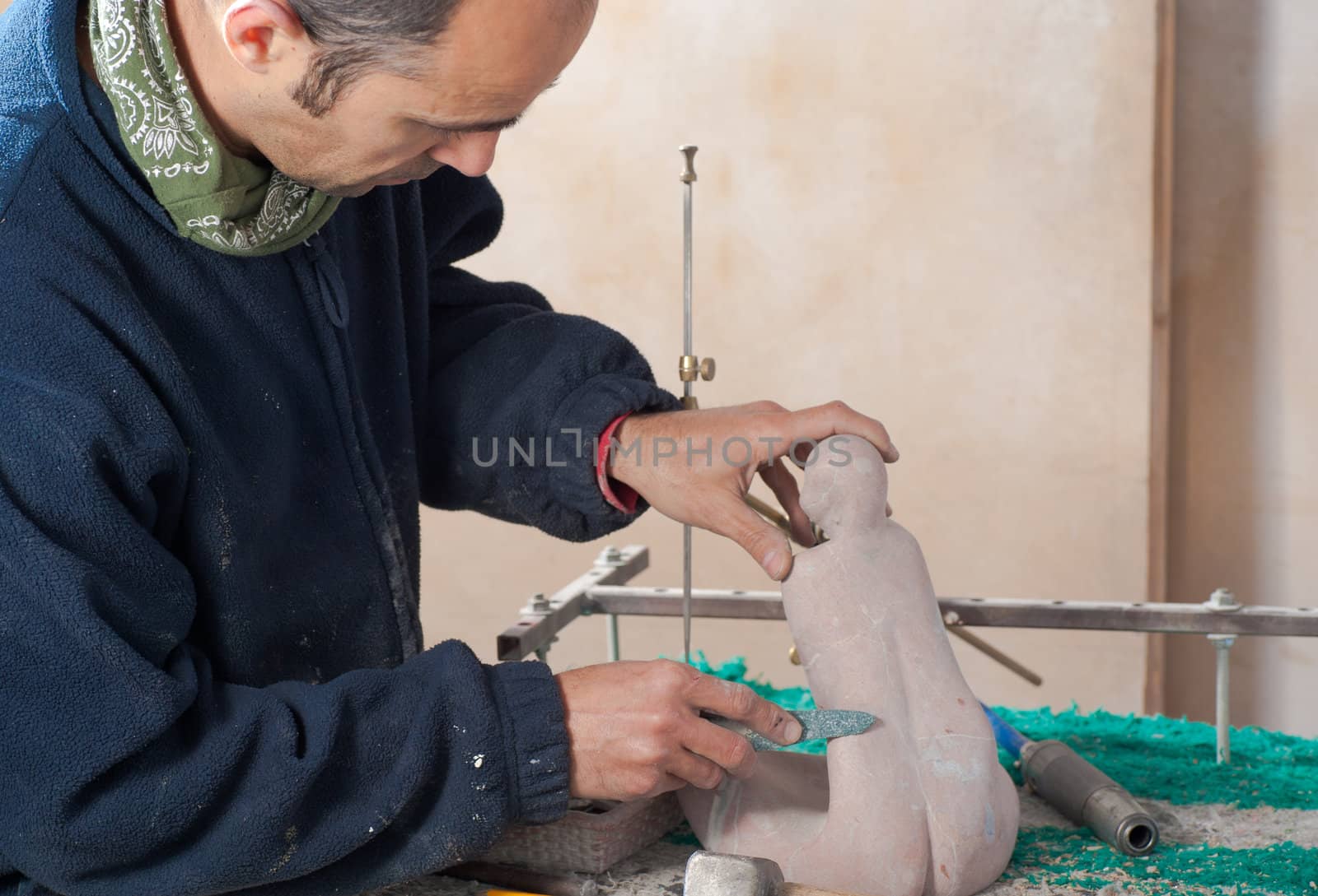 Sculptor patiently working on a small marble statue