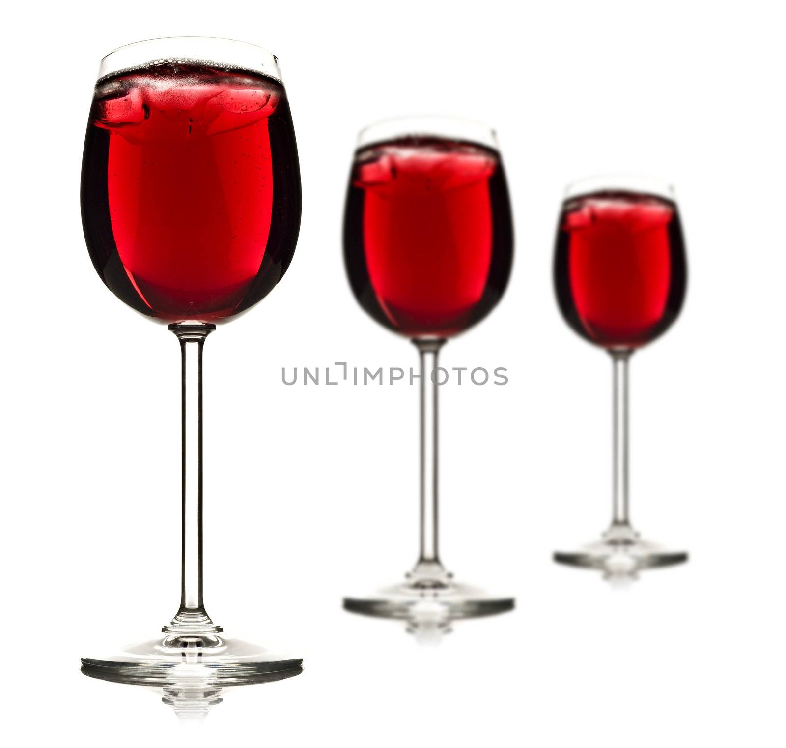 Three wine glasses with red fruit juice and ice - shallow depth of field