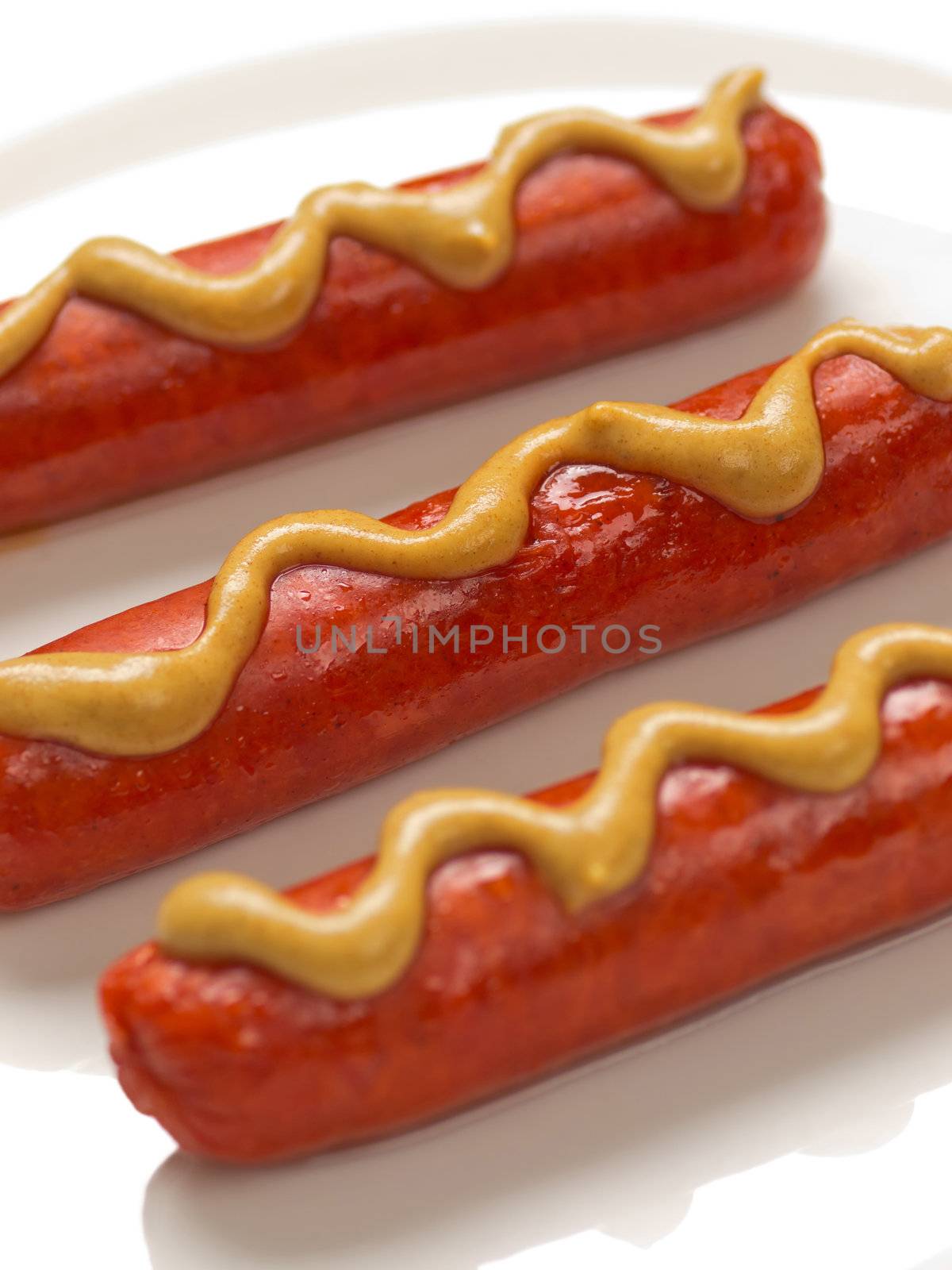 sausages with mustard sauce on a plate
