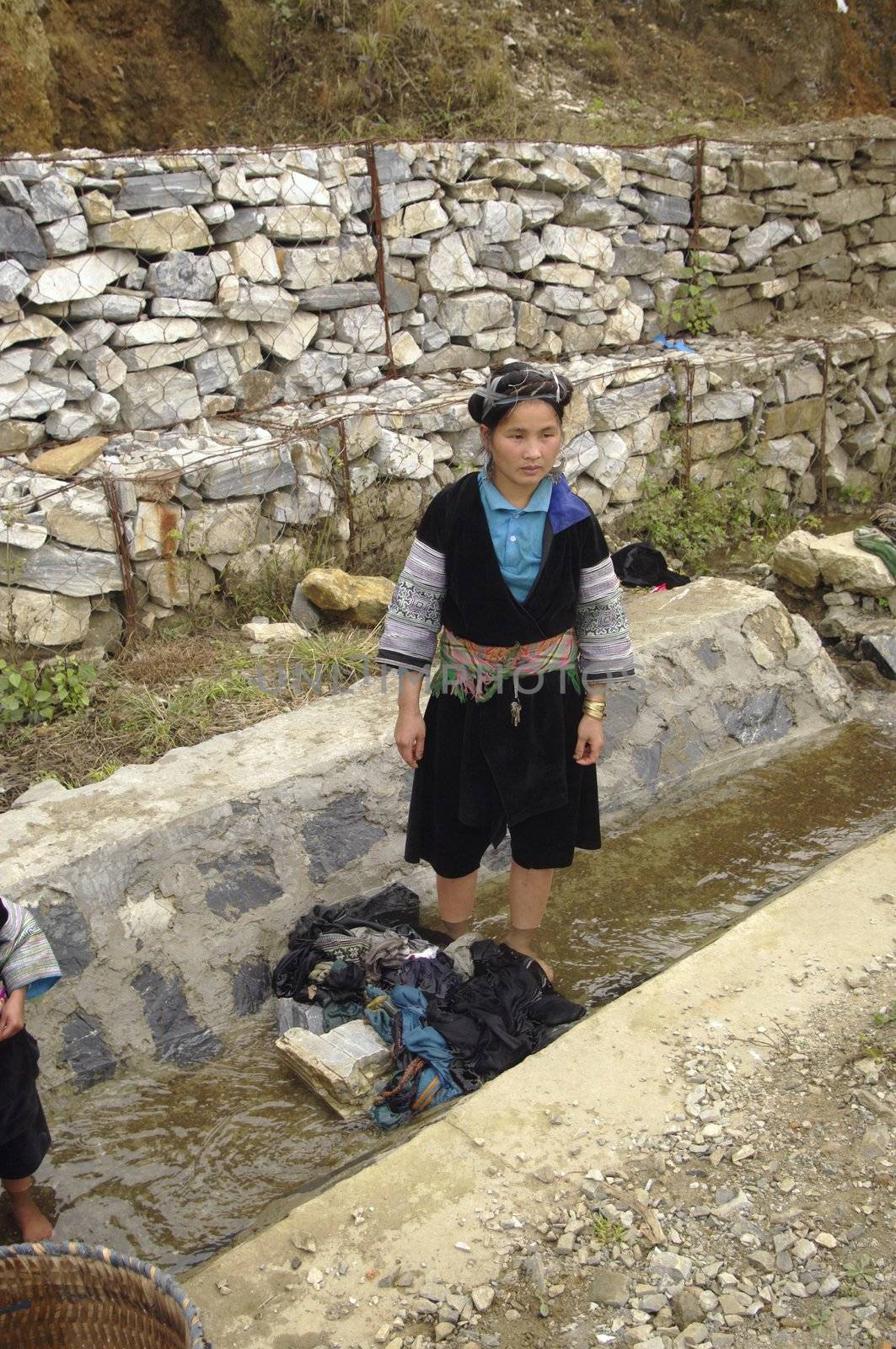 Woman washing clothes in the gutter fed water from the mountain