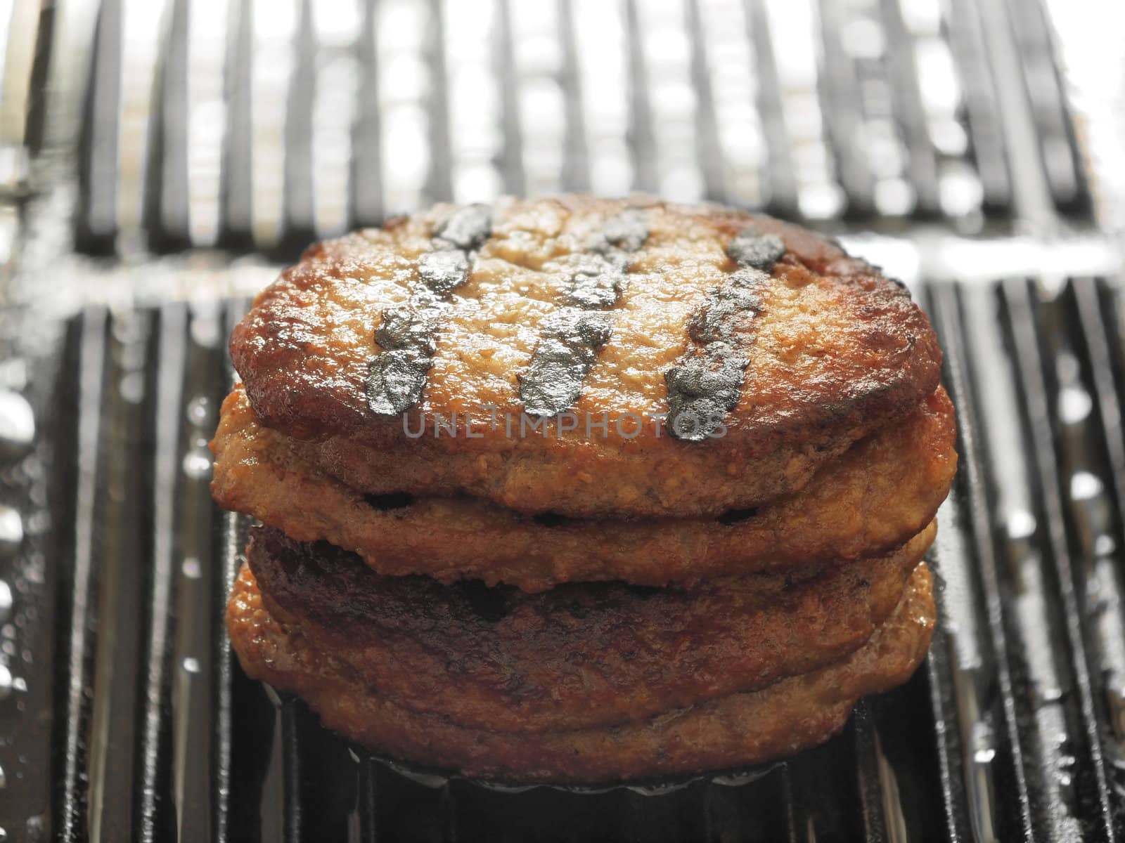 stack of grilled beef patties on a grill