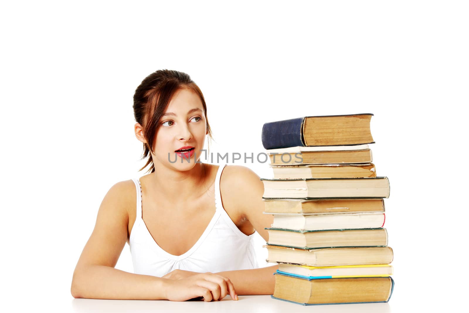 Young girl looking at the pile of books. by BDS