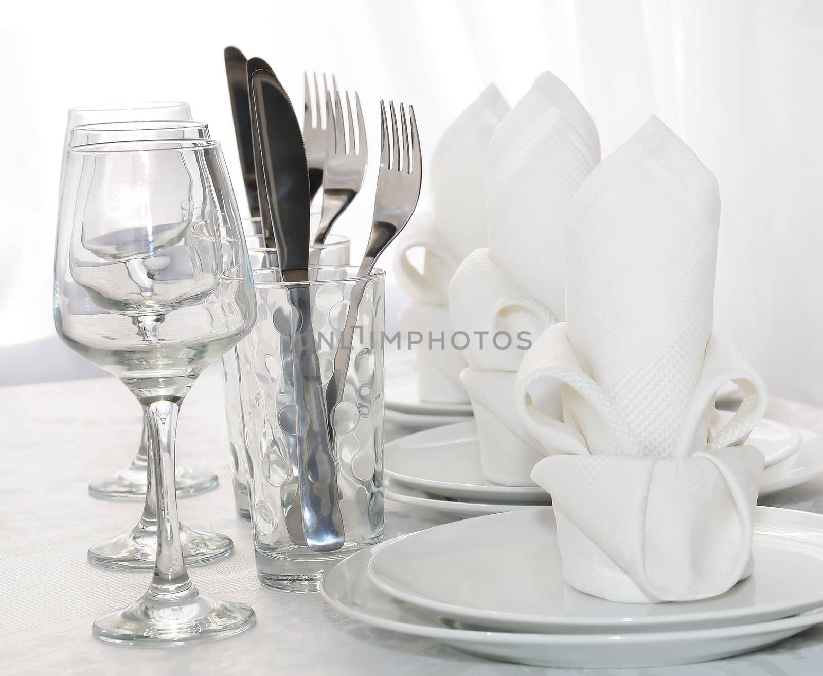 Decoratively folded napkins with glasses, glasses and cutlery