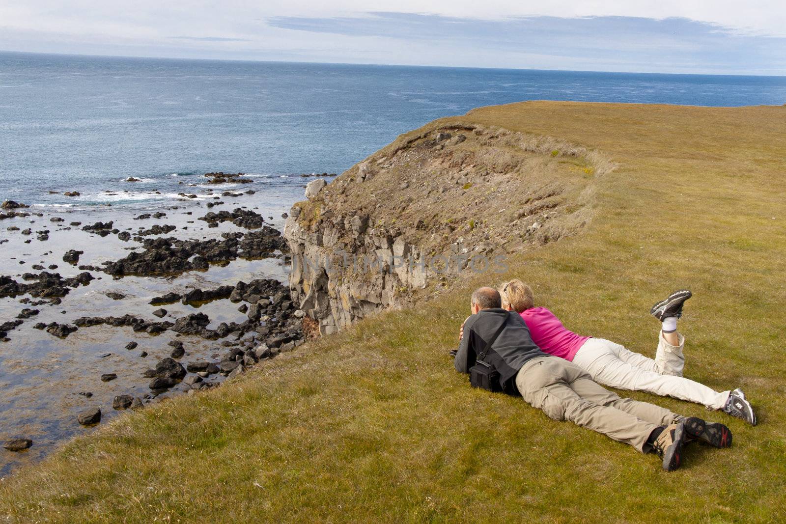 Couple on green grass  latrabjarg cliff - Iceland