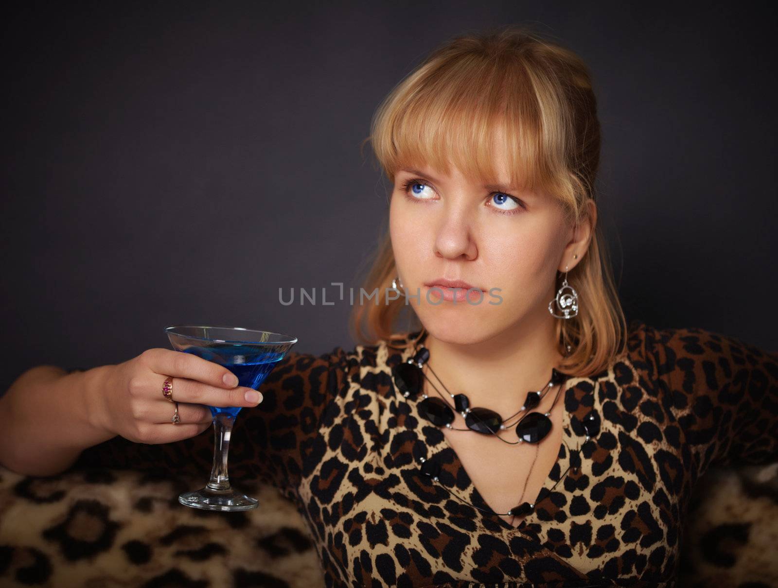 A beautiful young girl tries to exotic drink on black background