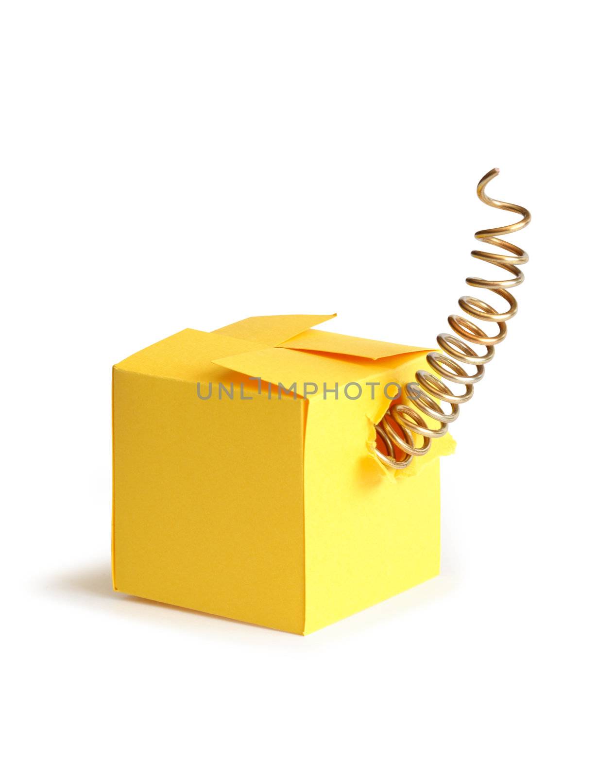 Metal spring inside closed yellow paper box. Isolated on white with clipping path