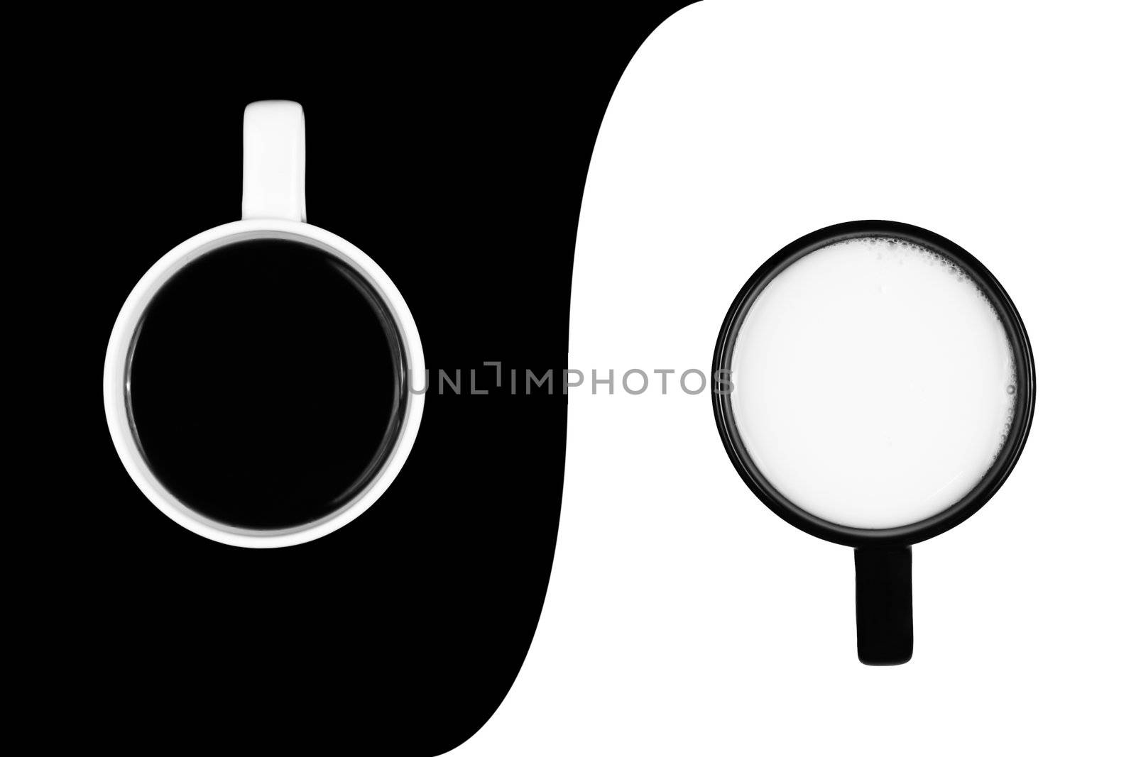A white cup of black coffe on black background and a black cup of white milk on a white background, separated by a curved border