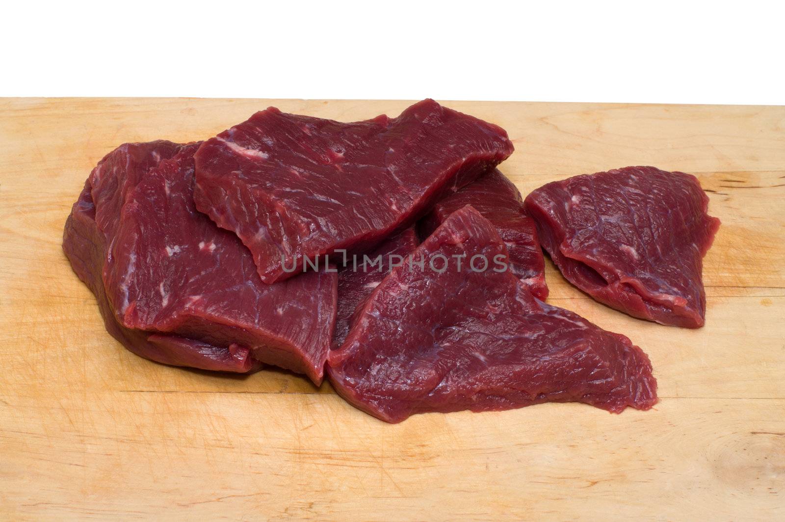 Piece of beef on a wooden cutting board.