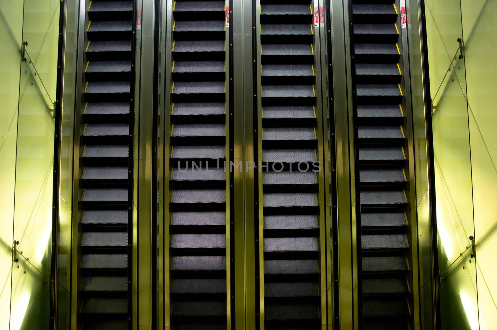 Escalator with sides lit up inside a shopping mall 