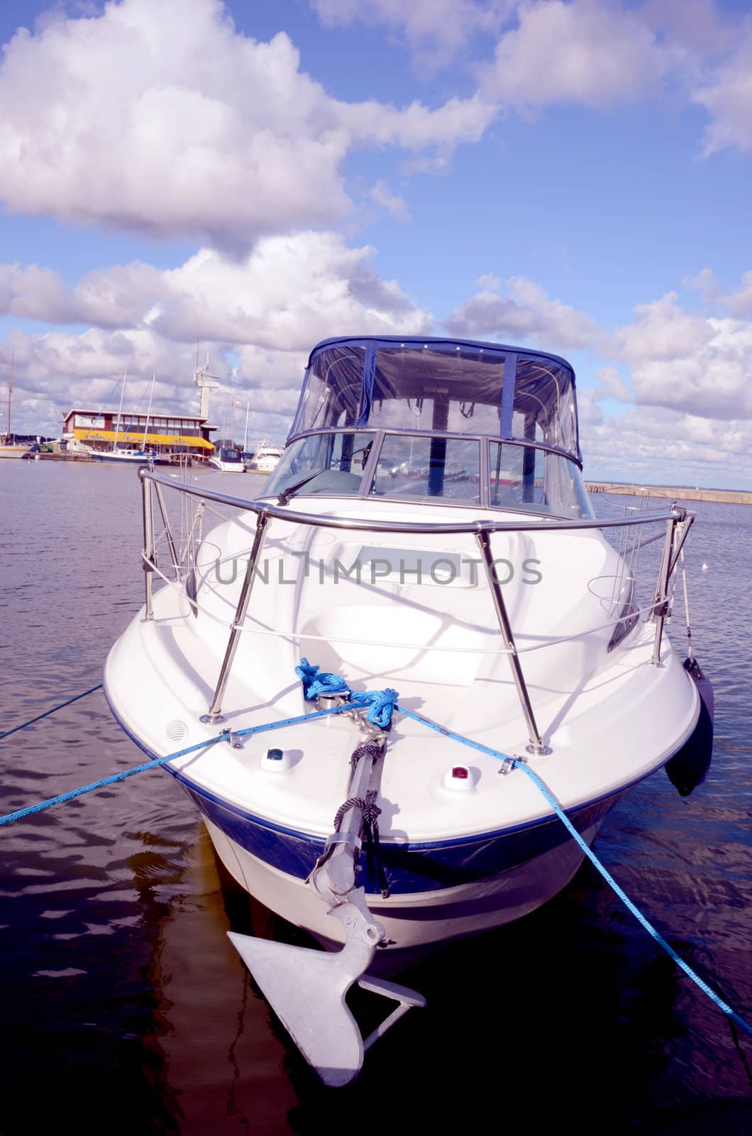 Boat moored at the lake marina. High speed water transport. Cloudy sky.