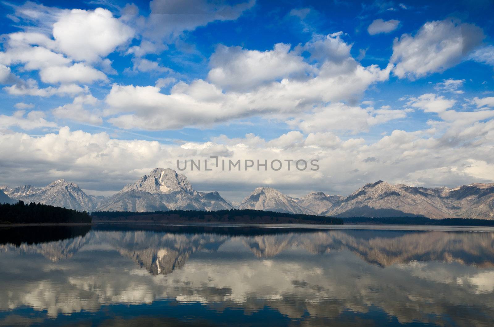 The Teton Mountains and puffy clouds reflected in Jackson Lake, Grand Teton National Park, Wyoming, USA by CharlesBolin