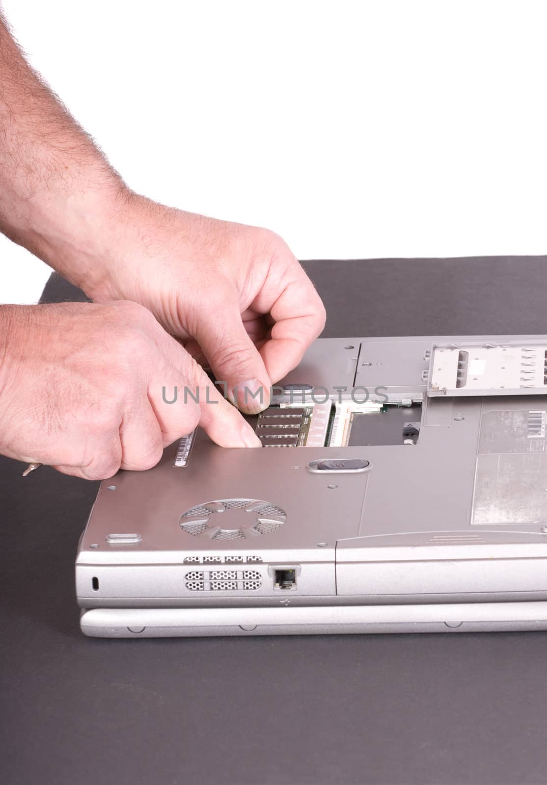 closeup of technician adding memory to a laptop