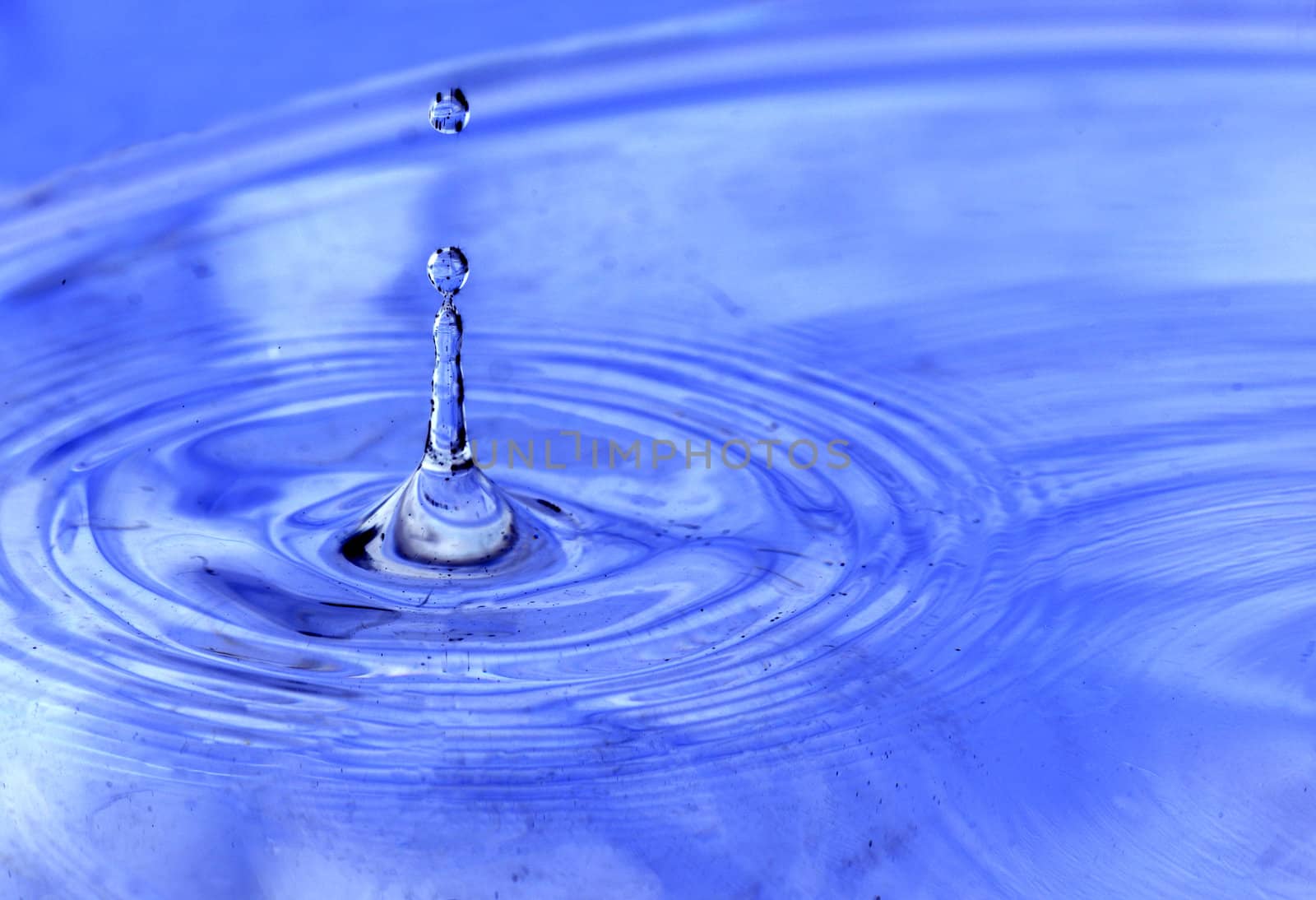 Water drops hitting the surface of a pool and creating unique abstract forms