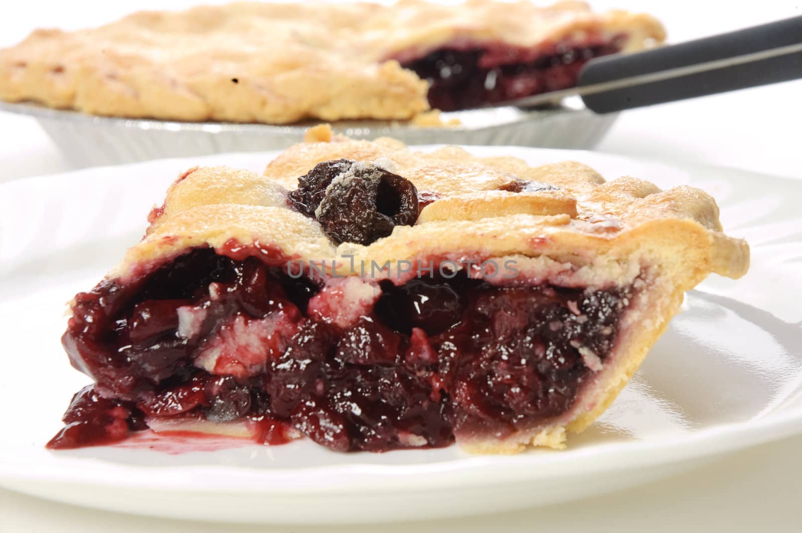 Slice of freshly cooked homemade cherry pie on a white plate 